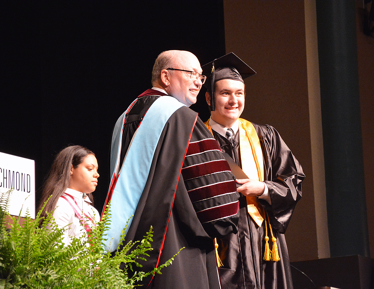 Graduate receives diploma from College President during graduation