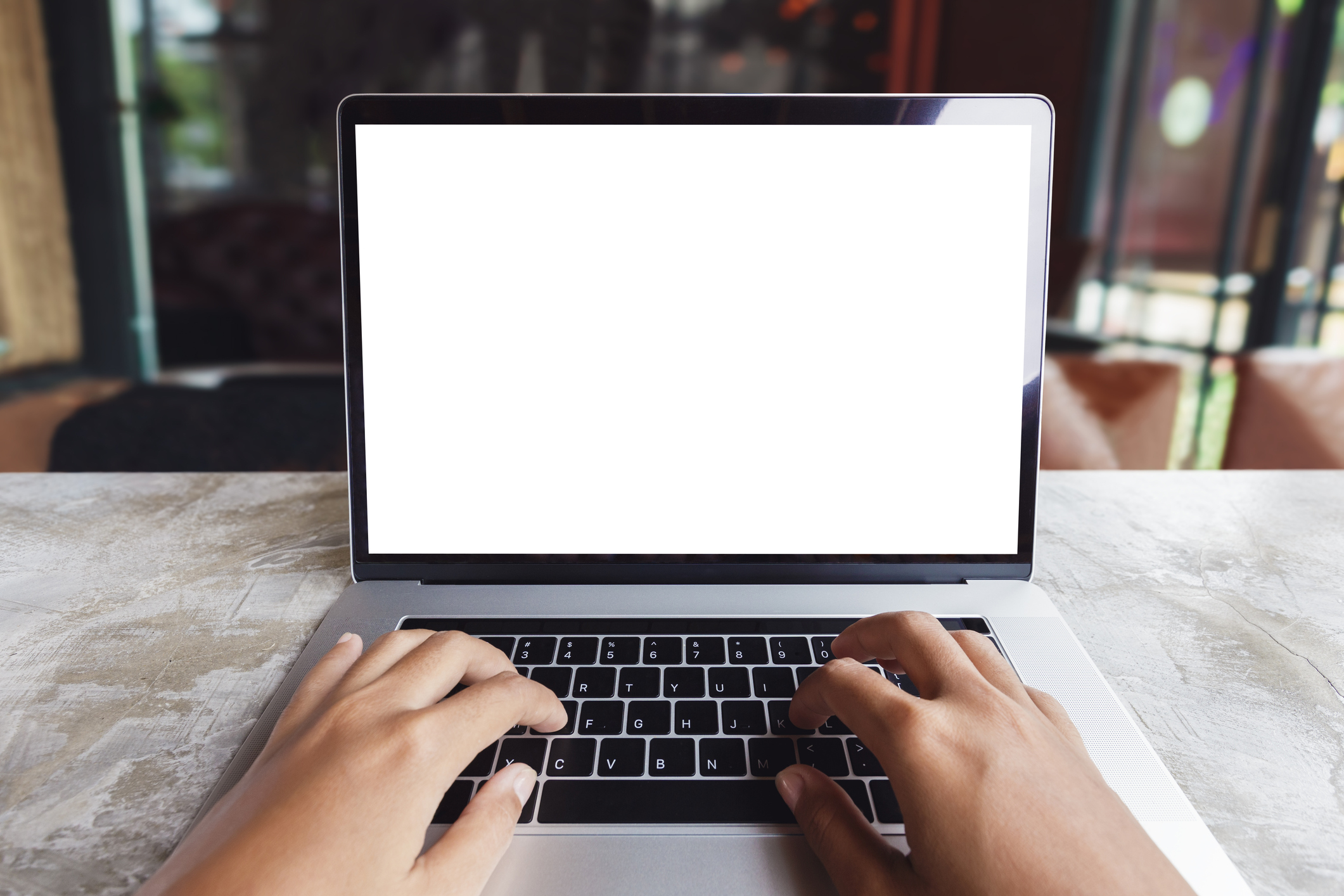 Person sitting at a laptop computer with hands on the keyboard